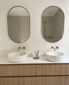 pristine bathroom with two hand basins with mirrors